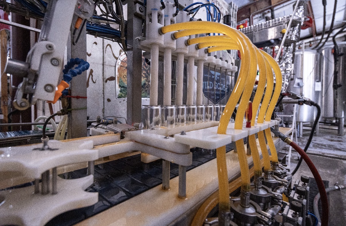 Aluminum cans on the filling line with yellow supply tubes at Connecticut Canning